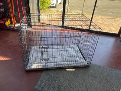 a cage with a dog inside of it on the floor