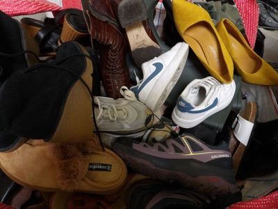 many pairs of shoes sitting in a basket on the floor