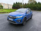 un SUV bleu garé sur un parking à côté d'un immeuble