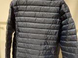 the back of a jacket hanging on a hanger in front of a white wall