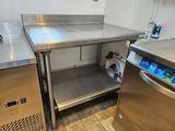un plan de travail en acier inoxydable et un lave-vaisselle dans une cuisine