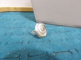 a ring with a shell on it sitting on a blue carpet