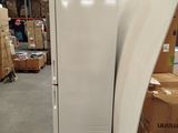 a white refrigerator sitting in a warehouse next to a pile of boxes