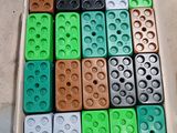 de nombreux Lego de différentes couleurs dans une boîte posée par terre