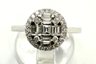 une photo d'une bague en diamant et en or blanc posée sur un socle transparent