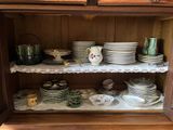 de nombreuses assiettes et tasses rangées sur une étagère dans un placard