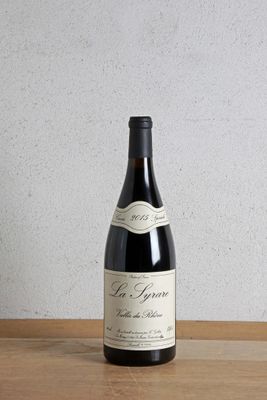 a bottle of wine sitting on a table next to a bottle of wine