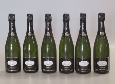 six bottles of champagne lined up in a row on a table