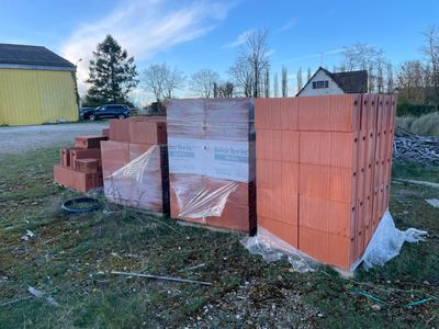 un tas de briques posé par terre devant un immeuble