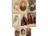 Plusieurs vieilles photos de personnes sont exposées sur une surface blanche