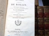 an open book sitting on a shelf in front of a bunch of books