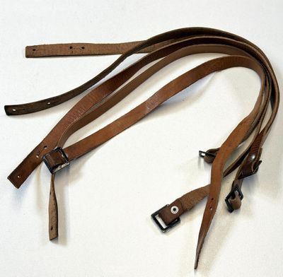une paire de lanières en cuir marron sur un fond blanc