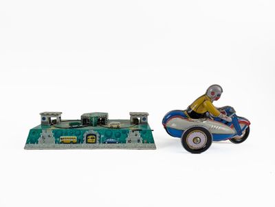 une petite voiture jouet et une petite maquette de voiture posées sur une surface blanche