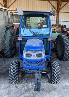 un tracteur bleu garé dans un bâtiment