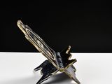 a black and gold sculpture of a butterfly on a white table