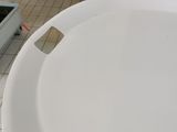 a white toilet bowl sitting on top of a tiled floor