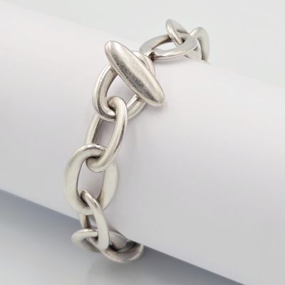 un gros plan d'un bracelet à chaîne en argent posé sur une serviette
