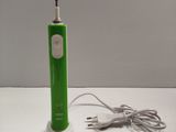 a green electric toothbrush sitting on a white table