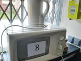 a microwave on a table with a cup on top of it