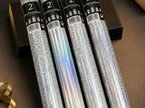 quatre rouleaux de papier d'argent posés sur une table, à côté d'un coffret cadeau