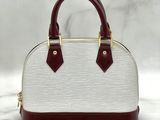 a white and maroon handbag with two handles on a marble surface