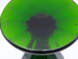 a green glass bowl with a black base