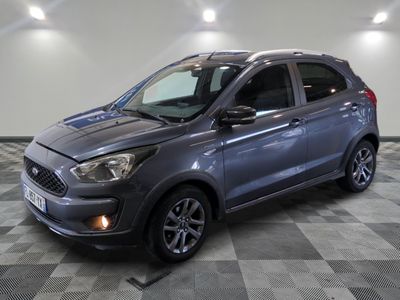 Une Ford Kad grise est garée dans une pièce au sol carrelé.