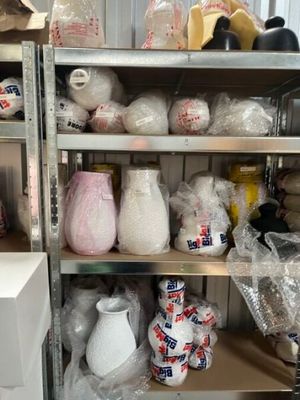 a shelf full of vases and other items in a room