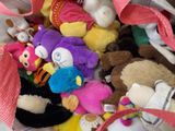 a pile of stuffed animals in a bag on the floor