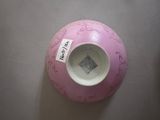 a pink vase with a tag on it sitting on a table