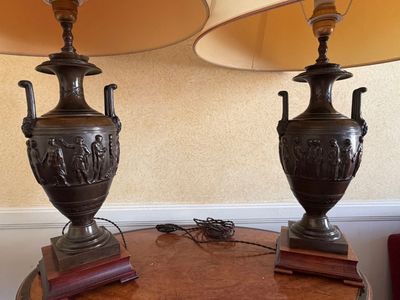 two lamps on a table with a lamp shade on top of it