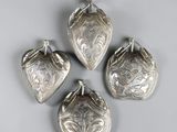 quatre clochettes plaquées argent sur fond blanc