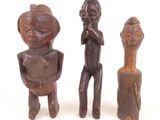 trois figurines en bois représentant un homme et une femme debout l'un à côté de l'autre