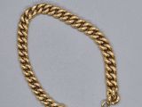 un bracelet à chaîne en or avec un fermoir sur fond blanc