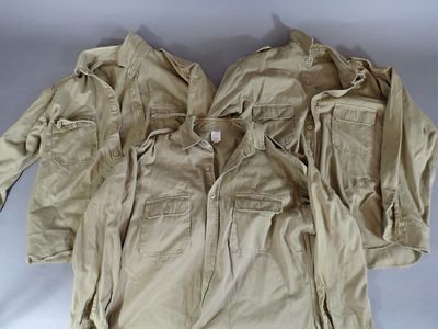 several jackets and pants are laid out on a white surface