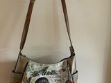 un sac à main accroché au mur, avec la photo d'une jeune fille dessus