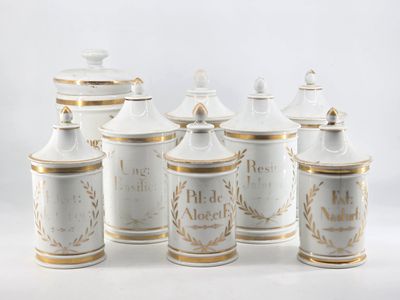 five white and gold canisters sitting on a white surface