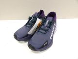 the purple and black running shoes are on a white surface