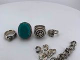 silver and turquoise rings and bracelets on a white surface