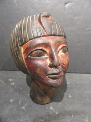 statue représentant la tête d'une femme coiffée d'un chapeau rayé