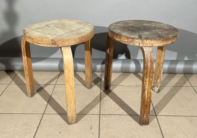 deux petits tabourets en bois posés sur un sol carrelé