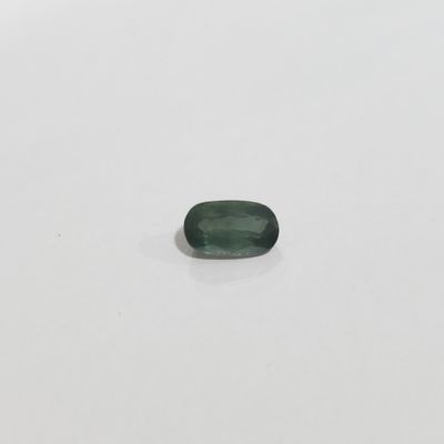 une tourmaline verte posée sur une surface blanche