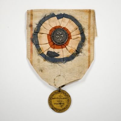 une vieille médaille ornée d'un médaillon, posée sur un fond blanc