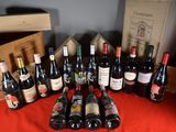 many bottles of wine sitting on a table with a red cloth