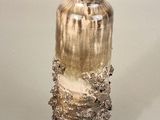 a glass vase with a brown and white design on it