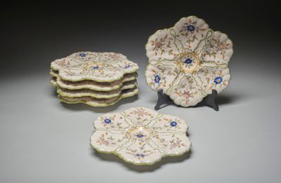 trois assiettes ornées de fleurs sont posées sur une table