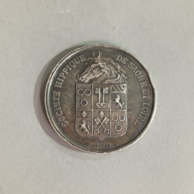 a close up of a silver coin on a white surface