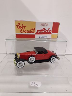 a red toy car in a clear display case