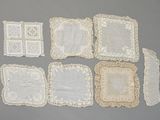 several white doily placemats and napkins on a gray surface