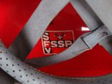 a close up of a red and white shoe with a gray strap